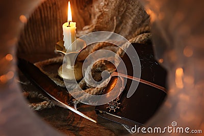 Retro book candle and feather Stock Photo