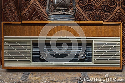 Retro broadcast radio receiver with blue eye light on wooden table circa 1950 front retro wall background. Listen music Stock Photo