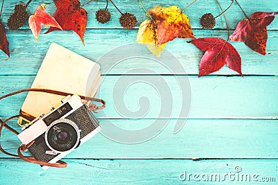 Retro camera and empty old instant paper photo album on wood table with maple leaves in autumn border design Stock Photo