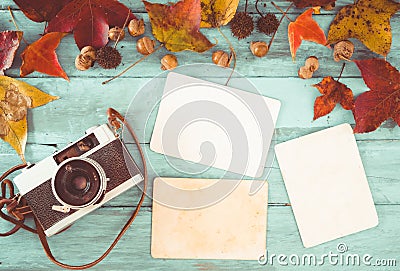 Retro camera and empty old instant paper photo album on wood table with maple leaves in autumn border design Stock Photo