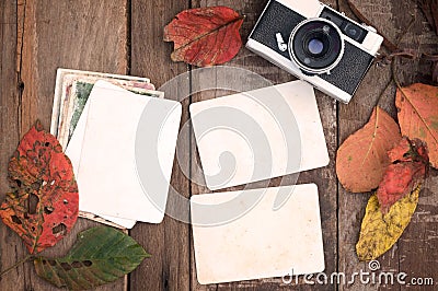 Retro camera and empty old instant paper photo album on wood table with maple leaves in autumn border design Stock Photo