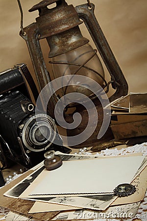 Retro camera, kerosene lamp and old photos Stock Photo