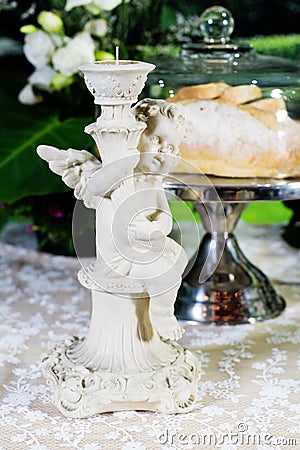 Retro candlesticks with candles on a table against bakery background Stock Photo