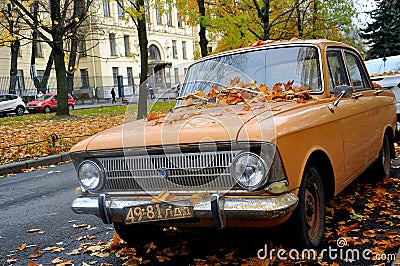 Retro car strewn with yellow leaves at the city street, Saint Petersburg, Russia Editorial Stock Photo