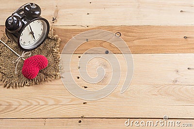 Retro clock with love heart yarn on wood background Stock Photo