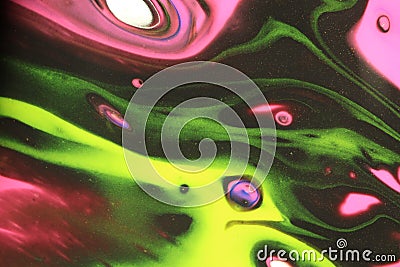 Vibrant neon yellow, green, and pink dance in black space in this abstract background. Stock Photo
