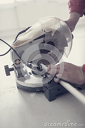 Retro effect faded and toned image of a workman using an electric circular saw Stock Photo