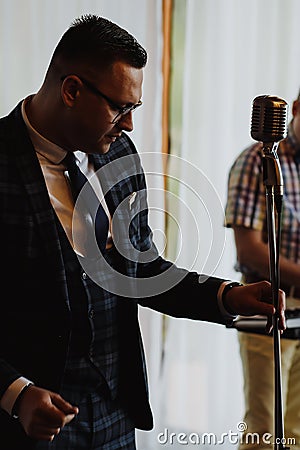 Retro fifties singer with vintage microphone and sunglasses. Studio shot Stock Photo