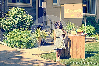 Retro girl wearing sunglasses with lemonade stand Stock Photo