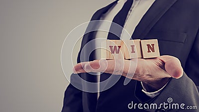 Retro image of businessman holding wooden alphabet blocks reading Win Stock Photo