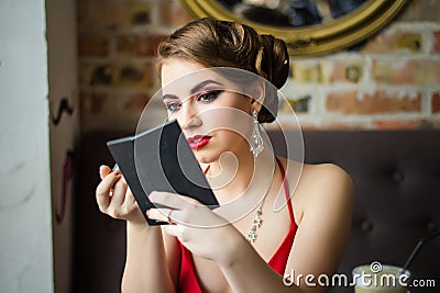 Retro image. Girl paints her lips red lipstick Stock Photo