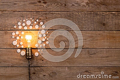 Retro light bulb and group of gears on wooden background - idea, innovation, teamwork and leadership concept. Space for text Stock Photo