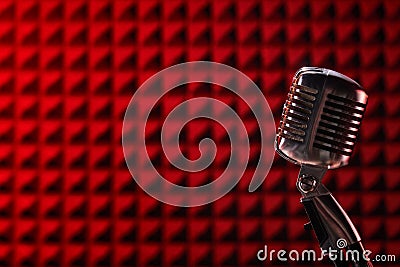 Retro microphone on acoustic foam panel background Stock Photo