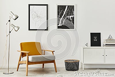 Retro and minimalist compositon of living room interior with design armchair, two mock up poster map, lamp, decoration, white wall Stock Photo