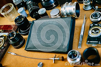 Retro mockup, retro black pack for photo paper in center and vintage photographic accessories and quipments around. Closeup side Stock Photo