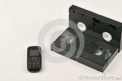 Retro objects on a white background. push-button telephone and video cassette. Analog media technology of the past. Copy space Stock Photo