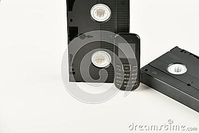 Retro objects on a white background. push-button telephone and video cassette. Analog media technology of the past. Copy space Stock Photo