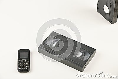 Retro objects on a white background. push-button telephone and video cassette. Analog media technology of the past. Copy space Stock Photo