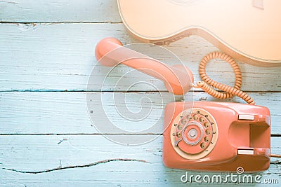 Retro orange-red telephone and the guitar Stock Photo