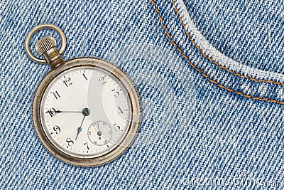 Retro pocket watch with blue jeans denim material Stock Photo