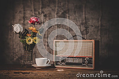 Retro radio receiver are still life with coffee cup and flower vases Stock Photo