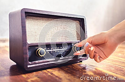 Retro radio tuning. Woman using old vintage music equipment. Adjusting volume or frequency tuner knob. Turning on or off stereo. Stock Photo