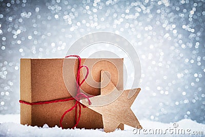 Retro rustic Christmas gift, present in snow on glitter background Stock Photo