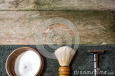 Retro safety razor, shaving brush and lather in bowl. Old-school wet shaving in rustic wooden table, with copy space. Stock Photo