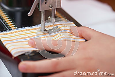 Retro sewing machine and child hand closeup, handmade and handicraft concept Stock Photo