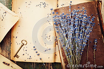 Retro still life with vintage books, key and lavender flowers, nostalgic composition on wooden table top view. Stock Photo