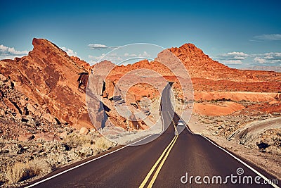 Retro stylized picture of a scenic desert road. Stock Photo
