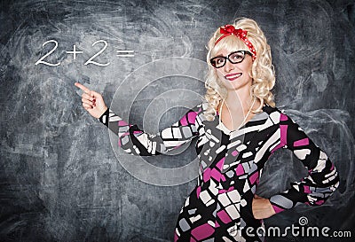 Retro teacher in glasses showing on equation by finger Stock Photo