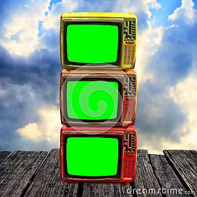 Retro television with green screen on wooden deck with clouds sky Stock Photo