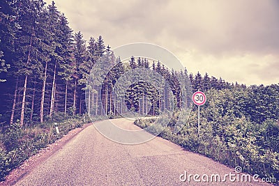 Retro toned road with speed limit sign Stock Photo