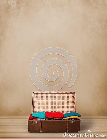 Retro tourist luggage with colorful clothes and copyspace Stock Photo