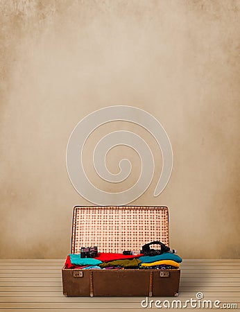 Retro tourist luggage with colorful clothes and copyspace Stock Photo