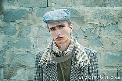 Retro and vintage old style. Stylish young man against a grey wall. Sexy male model dressed elegant, mans vogue. Stock Photo