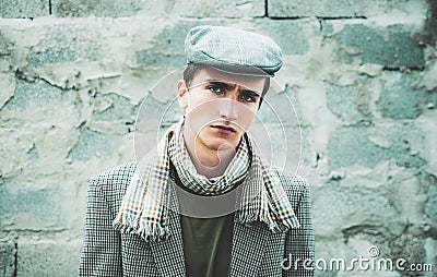 Retro and vintage old style. Stylish young man against a grey wall. Sexy male model dressed elegant, mans vogue. Stock Photo