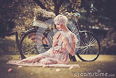 Retro woman sitting on a meadow Stock Photo