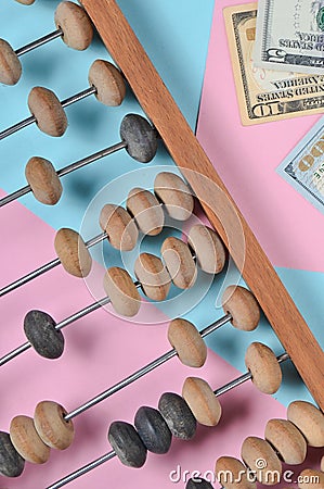 Retro wooden abacus, dollar bills on a colored paper background. top view. Stock Photo
