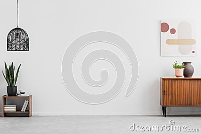 Retro, wooden cabinet and a painting in an empty living room interior with white walls and copy space place for a sofa. Real photo Stock Photo