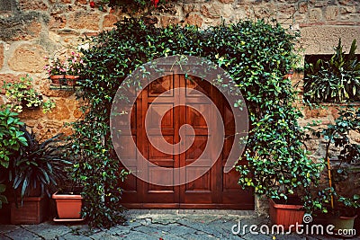 Retro wooden door outside old Italian house in a small town of Pienza, Italy. Vintage Stock Photo