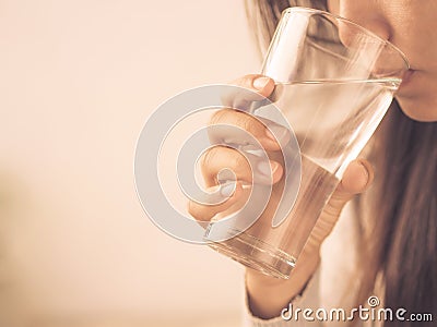Retro young woman drinking water from glass.Health care concept. Stock Photo