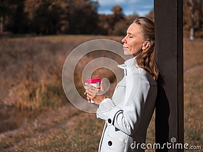 Reusable coffee cup in the hands of a woman. Stock Photo