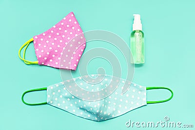 Reusable homemade fabric mask for the face and a sanitizer spray bottle. aqua background Stock Photo