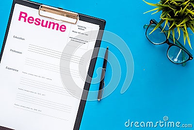 Review resumes of applicants set with glasses blue work desk background top view Stock Photo