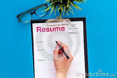 Review resumes of applicants set with glasses blue work desk background top view Stock Photo