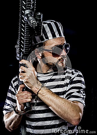 Revolt, Prison riot concept. Man holding a machine gun, prisoner Stock Photo