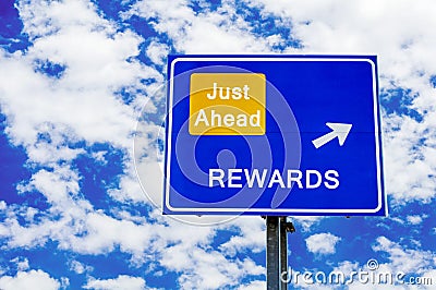 Rewards Blue Road Sign Against Blue Cloudy Sky Stock Photo