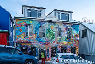Reykjavik bakery store facade with the facade decorated and painted with graffiti with the snowy roof and the street and cars with Editorial Stock Photo